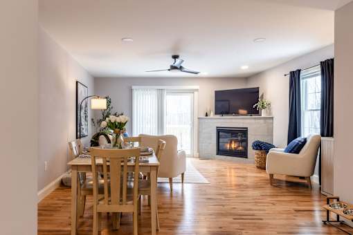 A living room with a fireplace and a dining table.