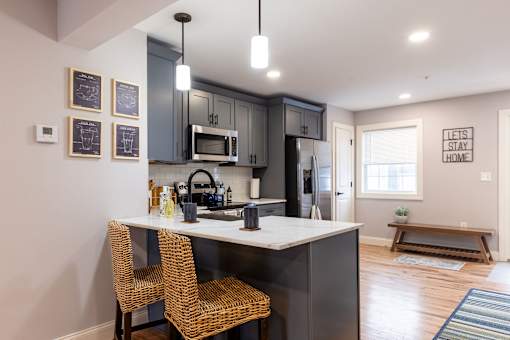 A kitchen with a white countertop and a black fridge.