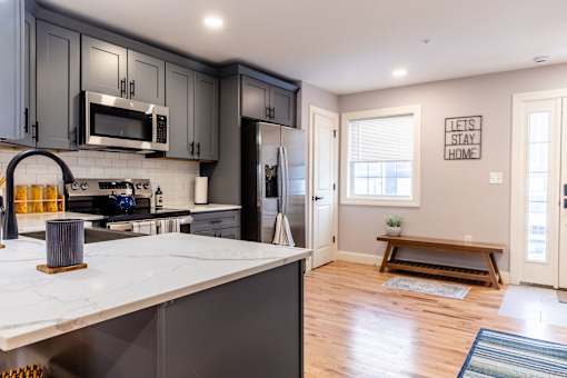 A kitchen with a white counter top and a refrigerator.