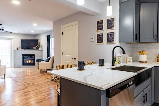 A modern kitchen with a white countertop and dark cabinets.