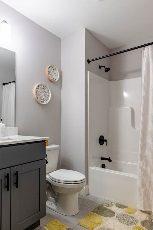 A bathroom with a toilet, sink, and shower.