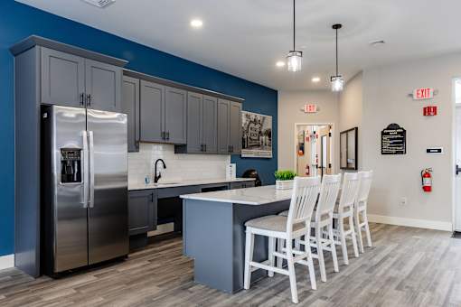 A kitchen with a blue wall and a stainless steel refrigerator.
