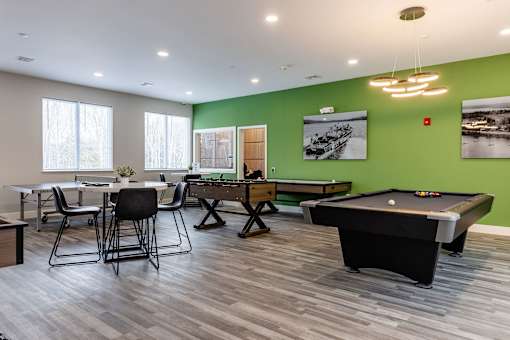 A room with a pool table and a dining table.