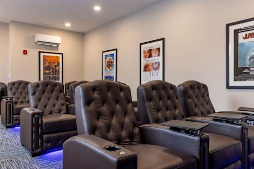 A row of black leather recliner chairs are lined up in a row.