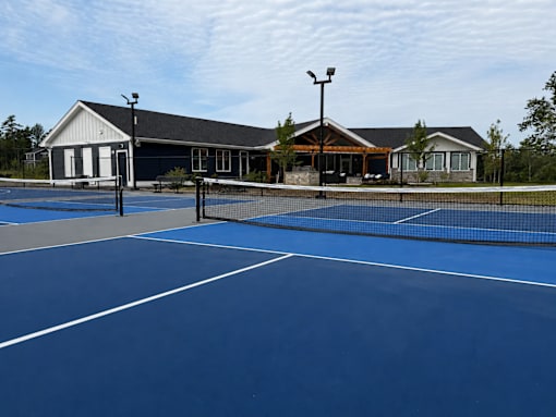 A tennis court with a building in the background.