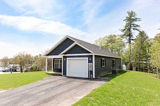 A two-car garage with a house attached is situated in a grassy area.