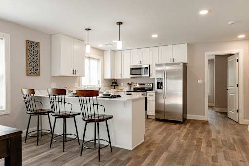 A kitchen with white cabinets and a refrigerator.