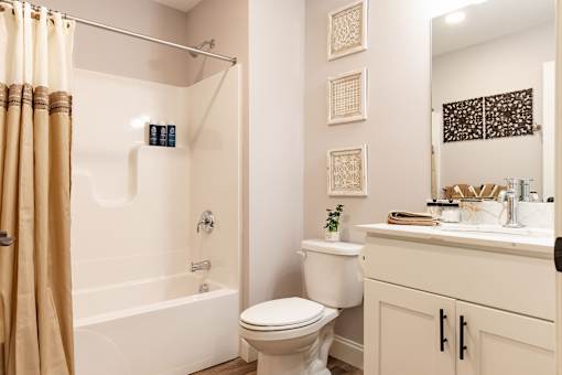 A bathroom with a toilet, sink, and shower.