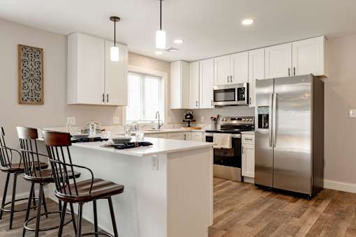 A modern kitchen with a white island and stainless steel appliances.