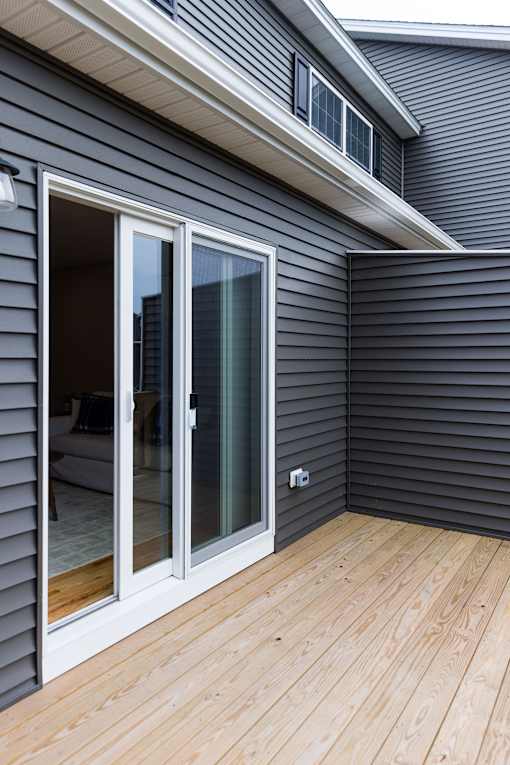 A grey house with a sliding glass door.