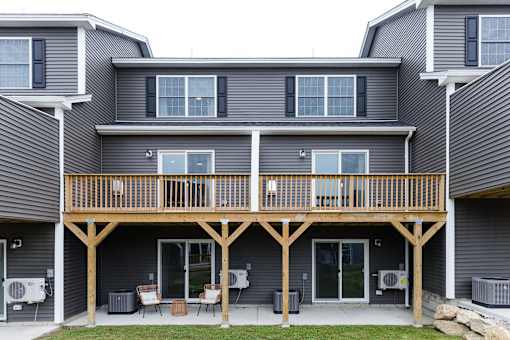 A grey house with a wooden balcony.