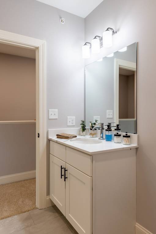 A bathroom with a sink, mirror, and light fixture.