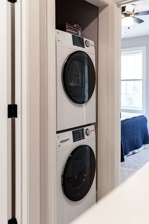 A white washing machine is in a cabinet.