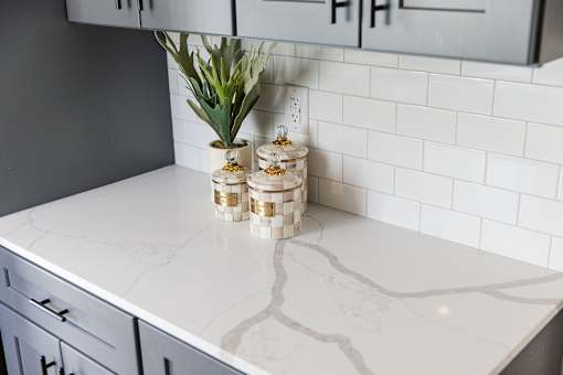 A white marble countertop with a plant and decorative items on it.
