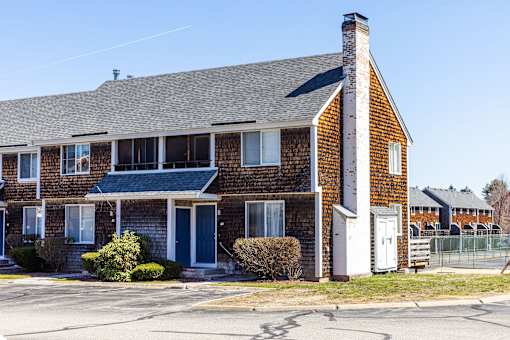 A brick house with a white door and windows.