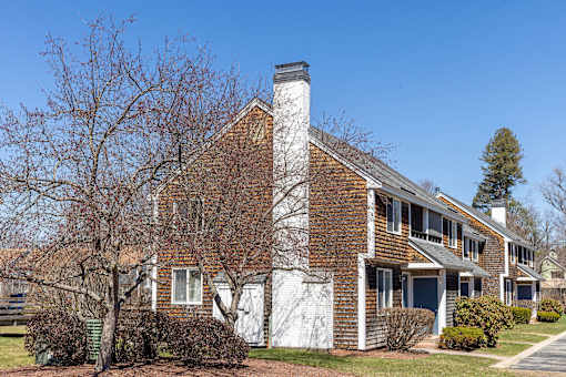 A white house with a brown roof and a chimney.
