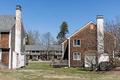 A red brick house with a white chimney and a porch.