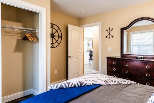 a bedroom with a bed and a dresser and a mirror