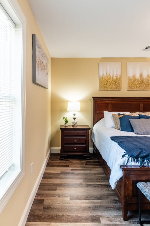 a bedroom with a bed and a nightstand and a window