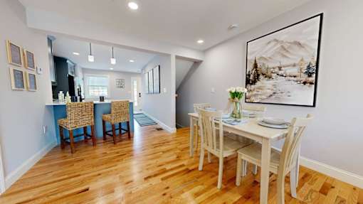 A dining room with a table set for four.