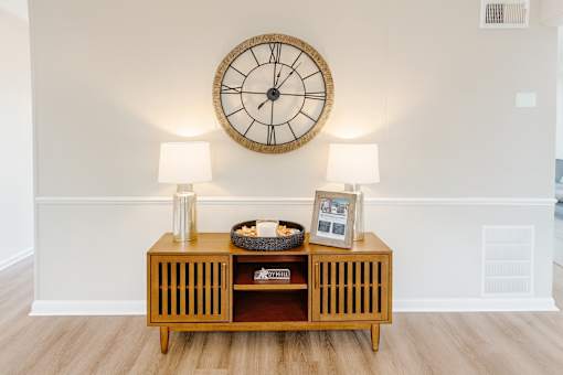 A wooden shelf with a clock above it.