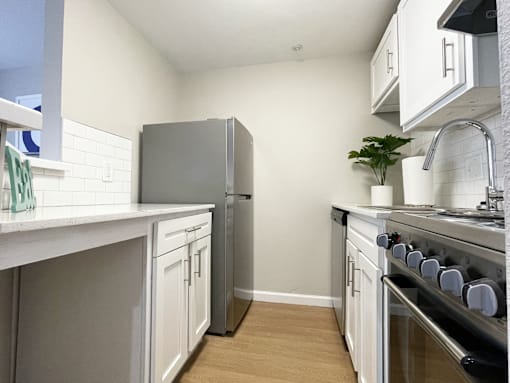 A kitchen with a refrigerator, stove, and sink.