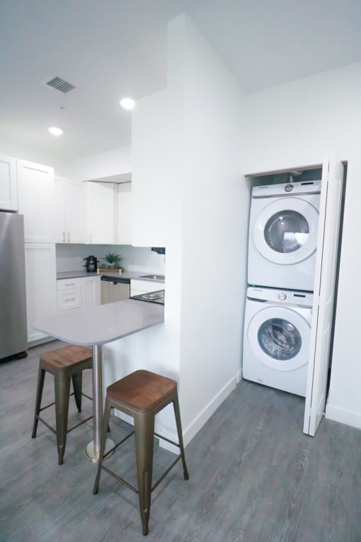 a kitchen with a washing machine and a table with chairs