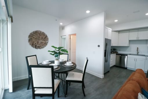 a dining room and kitchen with a table and chairs