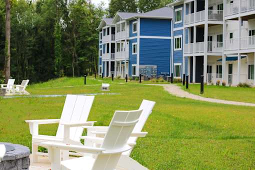 a group of lawn chairs in front of an apartment building