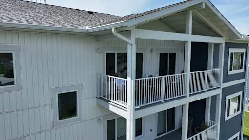 A white two-story building with a balcony.