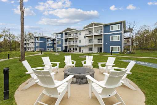 A blue and white apartment building with a patio area in front.