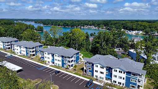an aerial view of multiple apartment buildings with a lake in the background