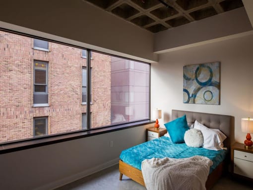 a bedroom with a bed and a large window