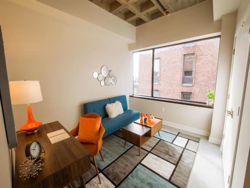 a living room with a blue couch and a large window