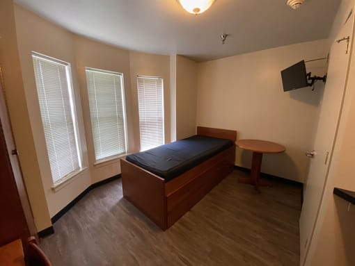 an empty bedroom with a bed and a table