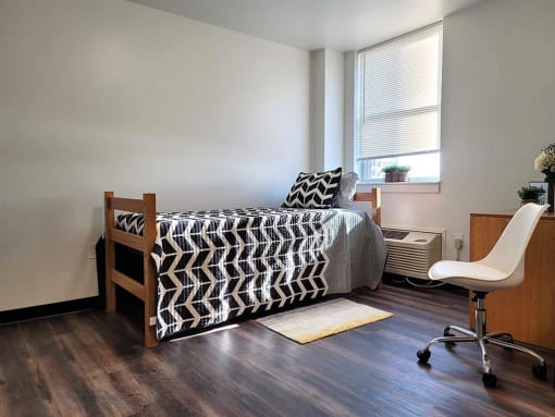 a bedroom with a bed and a chair and a window