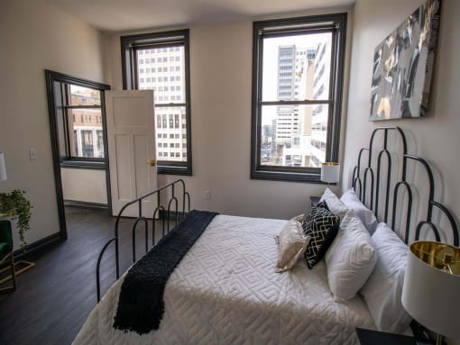 a bedroom with a bed and a view of the city