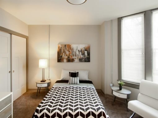 a bedroom with a bed and two windows