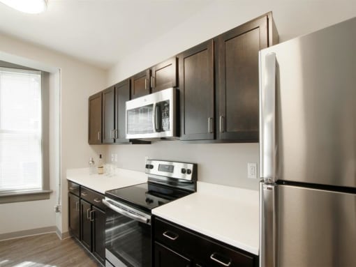 a kitchen with stainless steel appliances and black cabinets