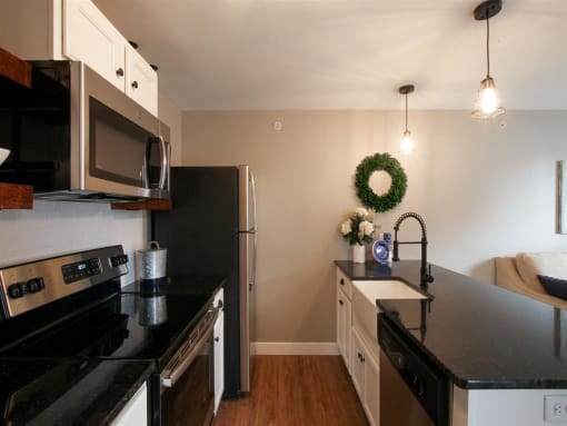a kitchen with black counter tops and stainless steel appliances