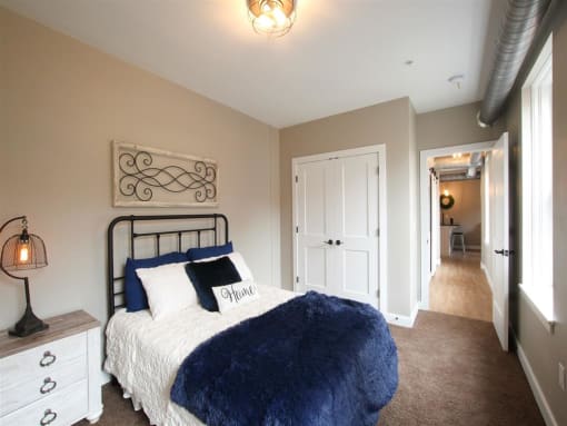 a bedroom with a bed and a hallway with a closet