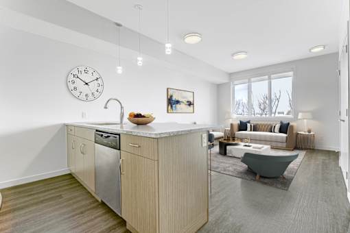 A modern kitchen with a large island and a clock on the wall.