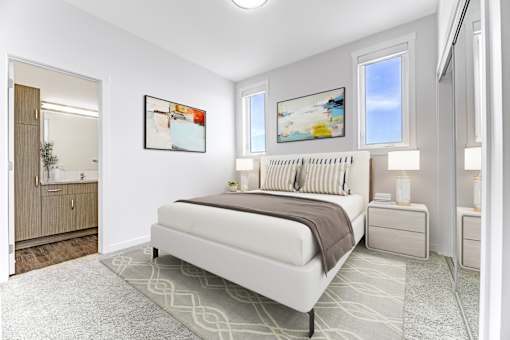 A bedroom with a large bed, two nightstands, and a painting on the wall.