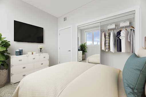 A bedroom with a large bed and a wardrobe with clothes hanging on it.