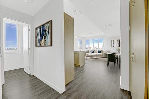 A living room with a grey floor and a painting on the wall.
