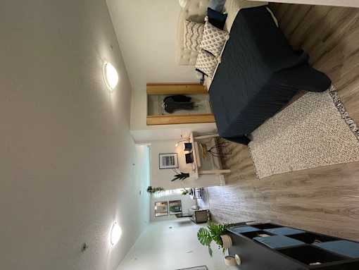 a small living room with a lofted bed and a view of the living room