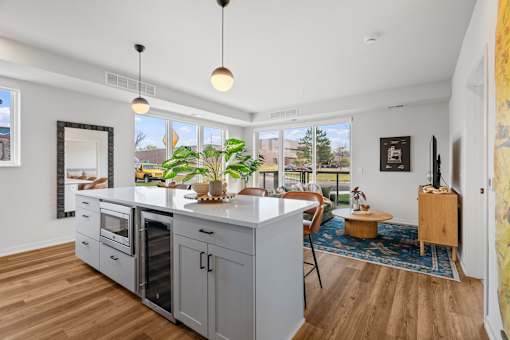 an open kitchen with a large island and a living room with a table and chairs