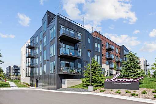 A modern multi-story building with a sign that reads "alma" in front of it.