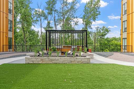 A black metal structure sits in the middle of a grassy area.