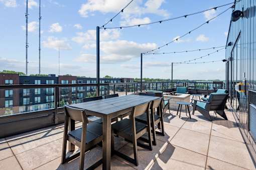 A table and chairs are set up on a rooftop patio.